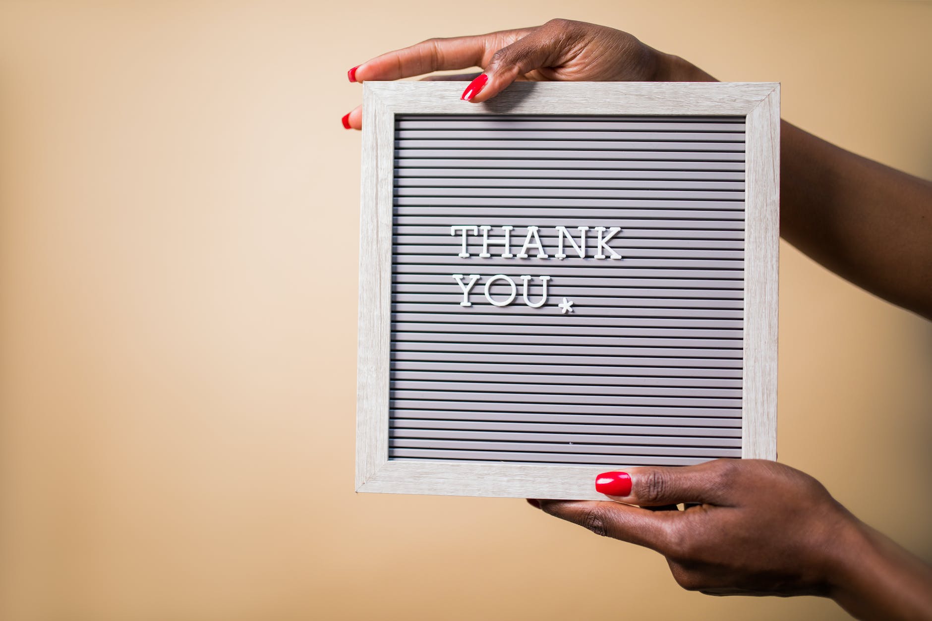 a person holding a gray thank you signage